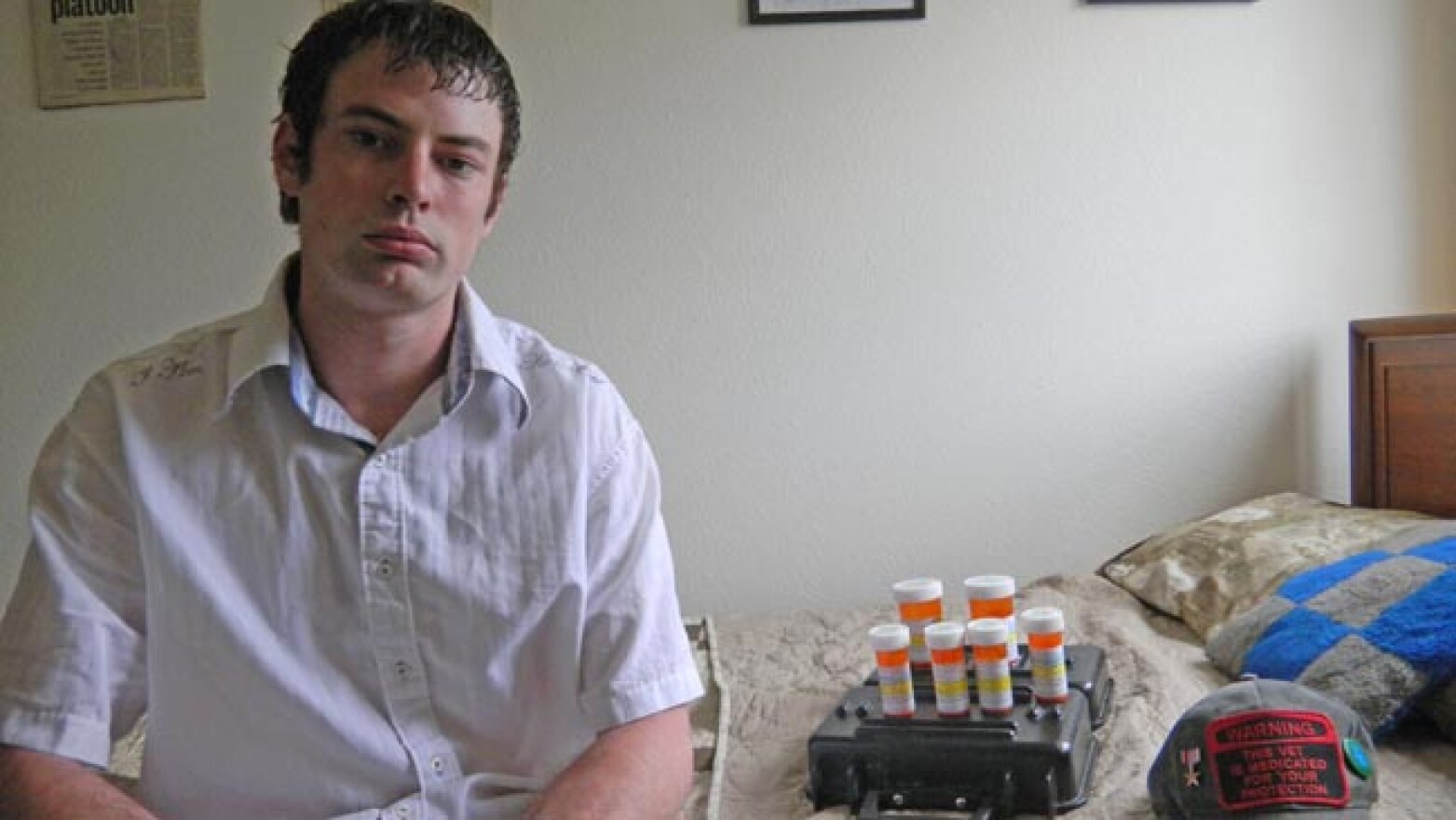 Army veteran Jarrid Starks, with his medications to treat PTSD and a hat that reads “Warning this vet is medicated for your protection.’ Photo by Austin Jenkins